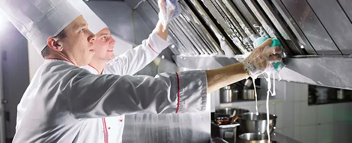 Chefs cleaning commercial kitchen ventilation and stainless steel equipment during maintenance service in North East Victoria